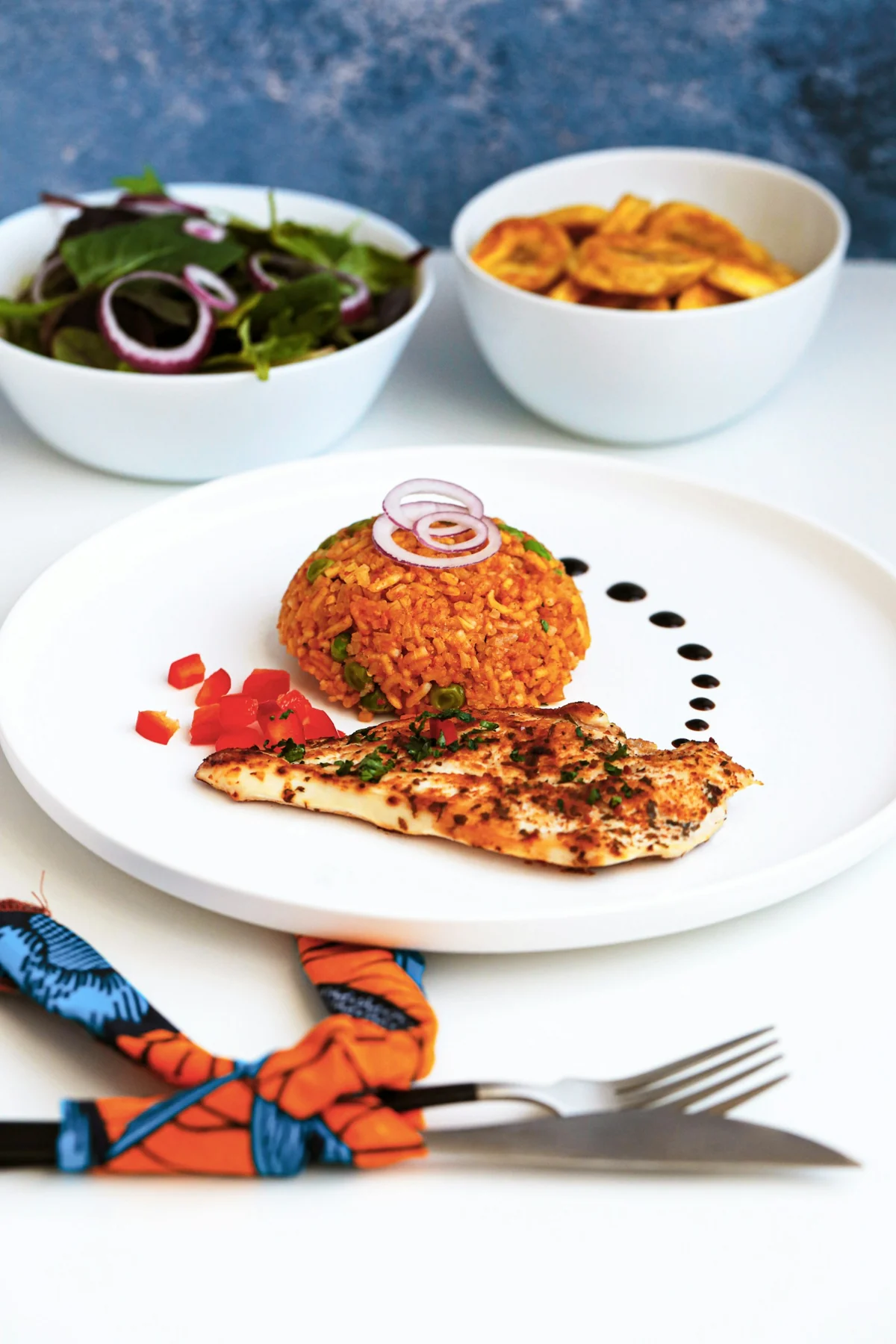 Nigerian jollof rice and chicken with salad and plantain